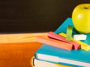 A book and a green apple resting on a table