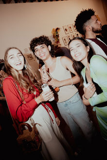 Three young creatives of color smiling and posing for camera.