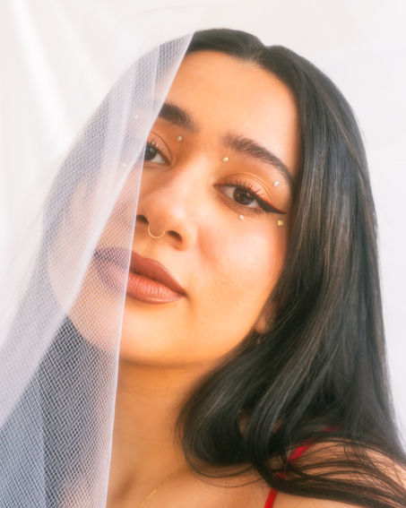 Sarah Elizabeth with a set transparent white fabric covering half her face