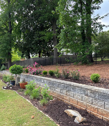 Stacked stone retaining wall with flowering landscape beds in metro Atlanta