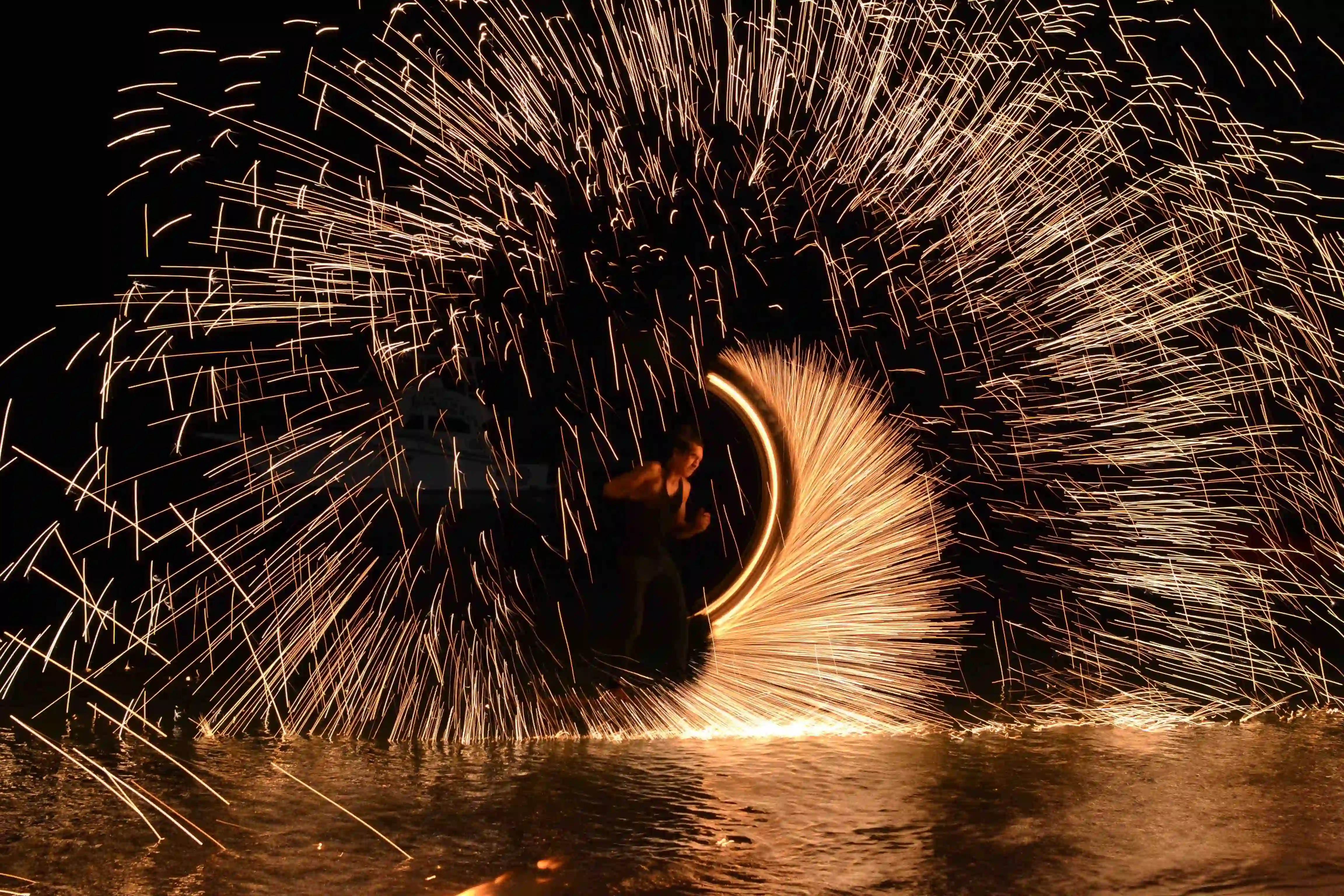 A man spinning fire at the beach 