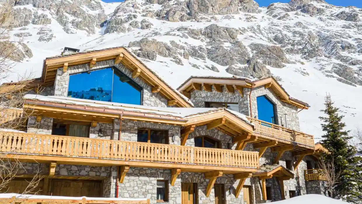 Large ski chalet in front of mountains