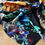Thumbnail: A large square silk scarf with abstract print in blue hues with cyan and yellow highlights