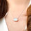 Thumbnail: Close up of a model's neck wearing a sterling silver necklace with a moonstone gem pendent