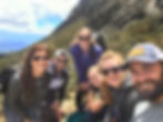 group of hikers on a trail smiling at the camera