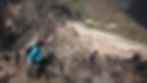 two girls climbing over rocks on a mountain