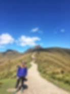 girl standing on trail with mountain in background