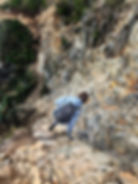 girl climbing down rocks on a mountain