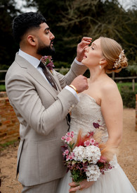 A blonde bride in a sweetheart fitted bodice lace gown and her new husband share a kiss