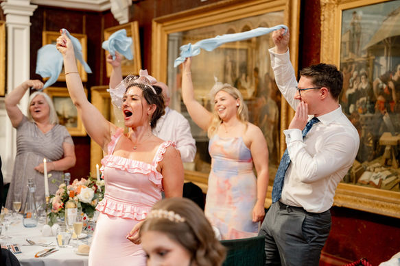 A guest waves her napkin to great the bride and groom 