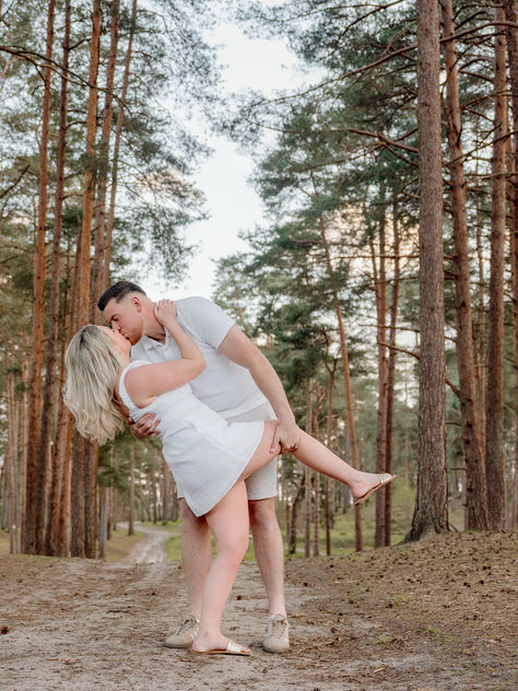 A couple in white kiss in the forest