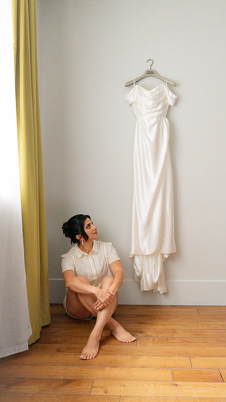 A bride looks up at her dress 