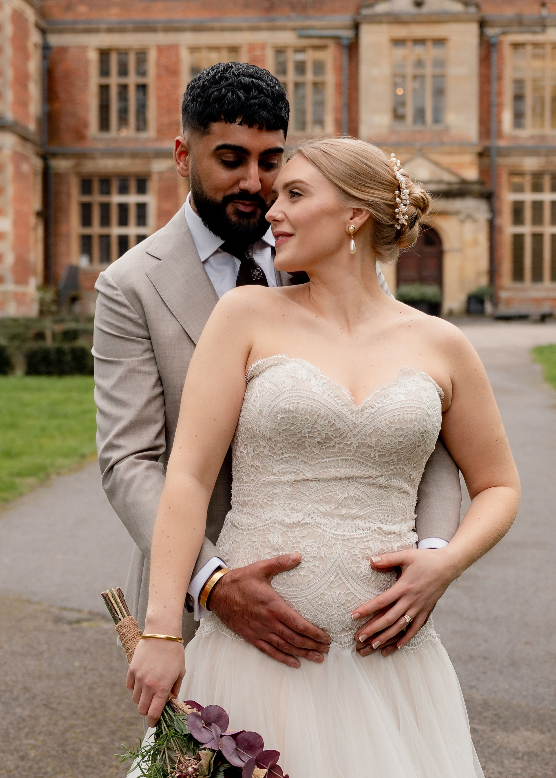 A blonde bride in a sweetheart fitted bodice lace gown and her new husband share a kiss