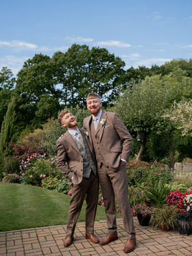 A groom and his groomsman stand in his garden before a wedding, documentary style storytelling 