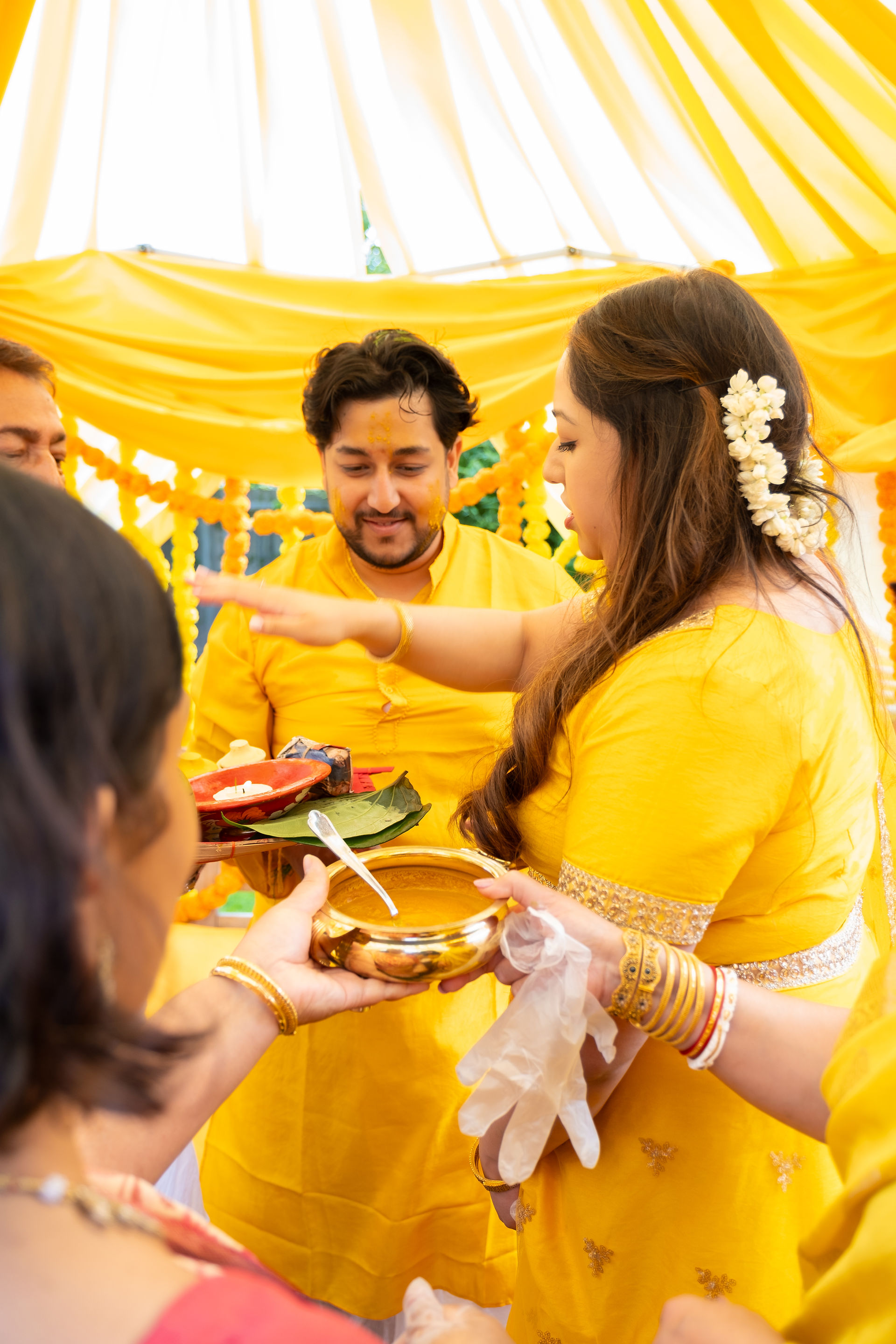 The groom sister gives blessings at a Gaye holud 