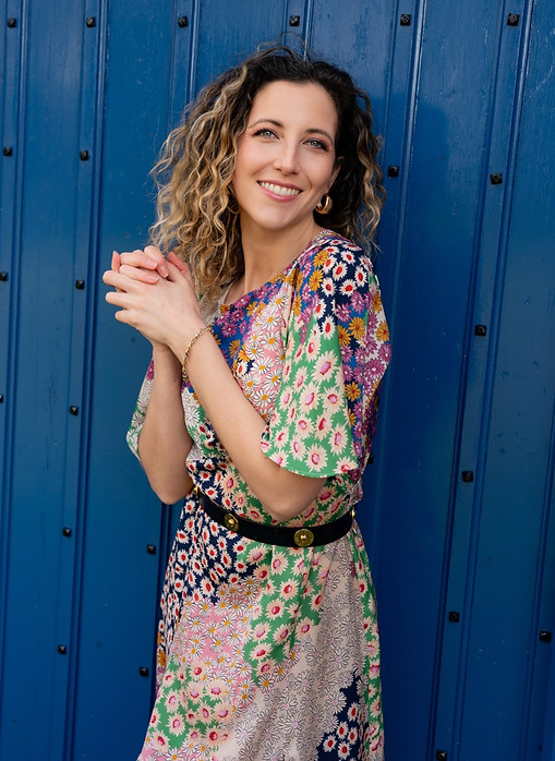 Lottie stands in front of a blue door, portrait photographer surrey