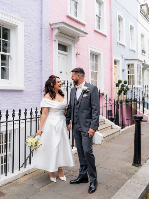 A couple stand in a pastel street