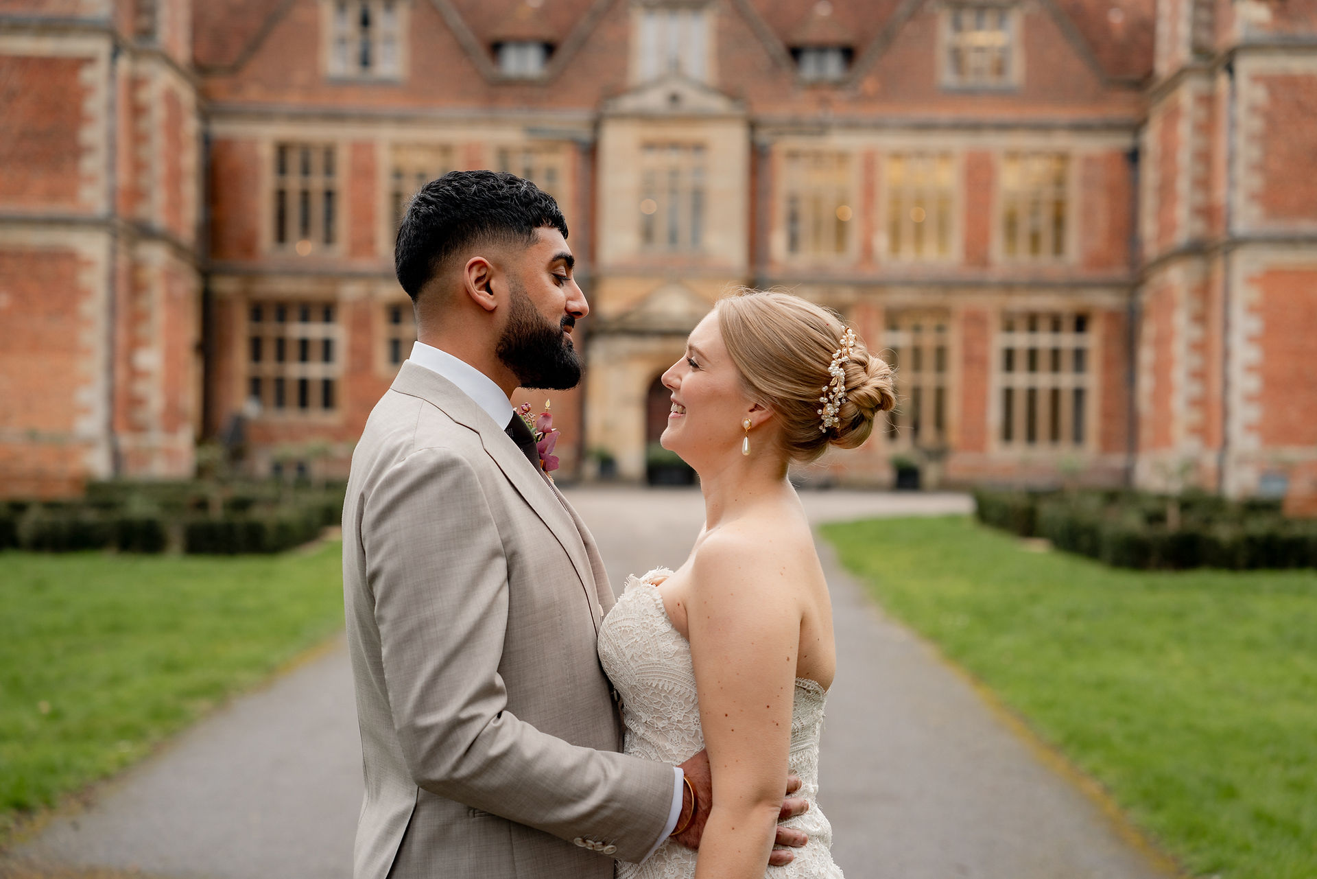 A blonde bride in a sweetheart fitted bodice lace gown and her new husband share a kiss