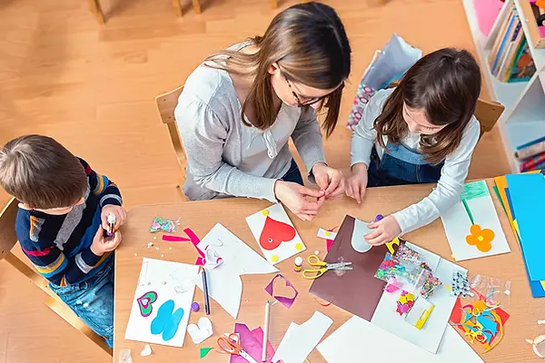 Crafting-Mom-and-Kids-at-Table-Making-Kids-Crafts.webp