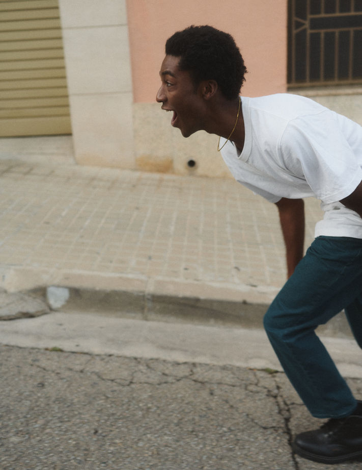 Lifestyle storytelling photography showing laughing a man in motion through residential streets in Sabadell, Barcelona. Photo by Félix L. Salazar based in Hamburg