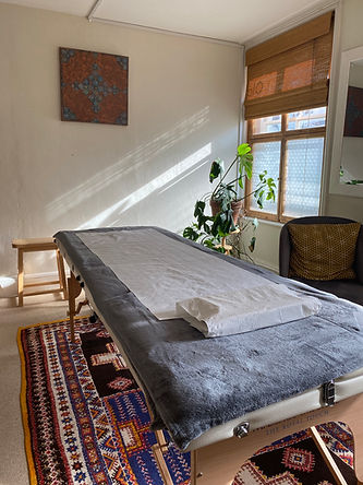 A therapy couch in a room with windows where Fumiaki Tanaka MSTAT, RCST offers Craniosacral therapy and the Alexander Technique at Ola Chiropractic in Totnes.