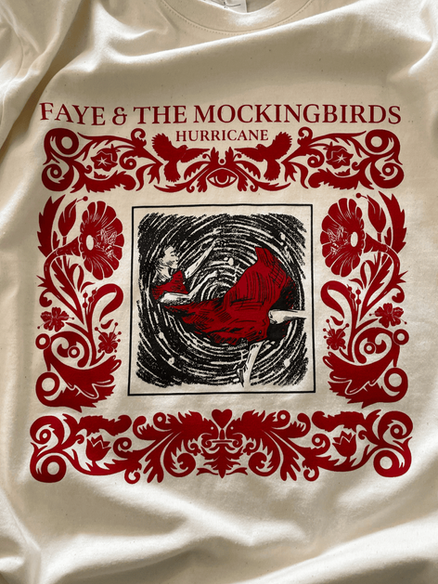 T-shirt crème avec graphisme rouge orné et illustration centrale d’un cyclone.