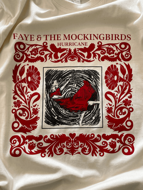 T-shirt crème avec graphisme rouge orné et illustration centrale d’un cyclone.