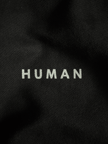 T-shirt noir brodé "HUMAN" - Broderie sobre et minimaliste sur tissu noir, une personnalisation textile raffinée et intemporelle.