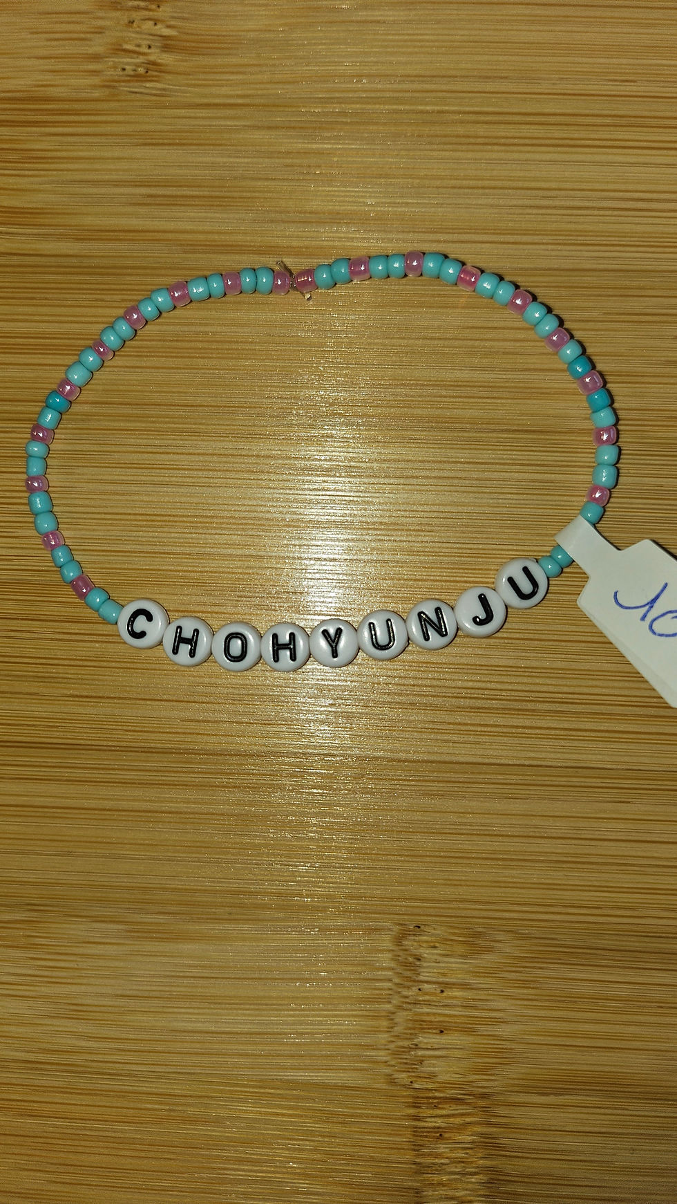 Bracelet de perles bleues et roses avec le nom CHOHYUNJU et étiquette, Kissbijoux.