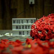 Will You Marry Me The Pop-Up Society proposal setting with red roses and a nice large sign that says will you marry me.