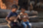 Two boys gently hold young goats