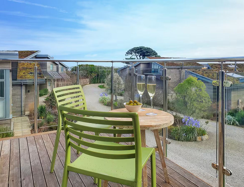 A table for two with a glass of wine on the balcony at Carbis Bay Lodge