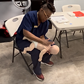 me doing a demo with infant mankin for choking lesson.png