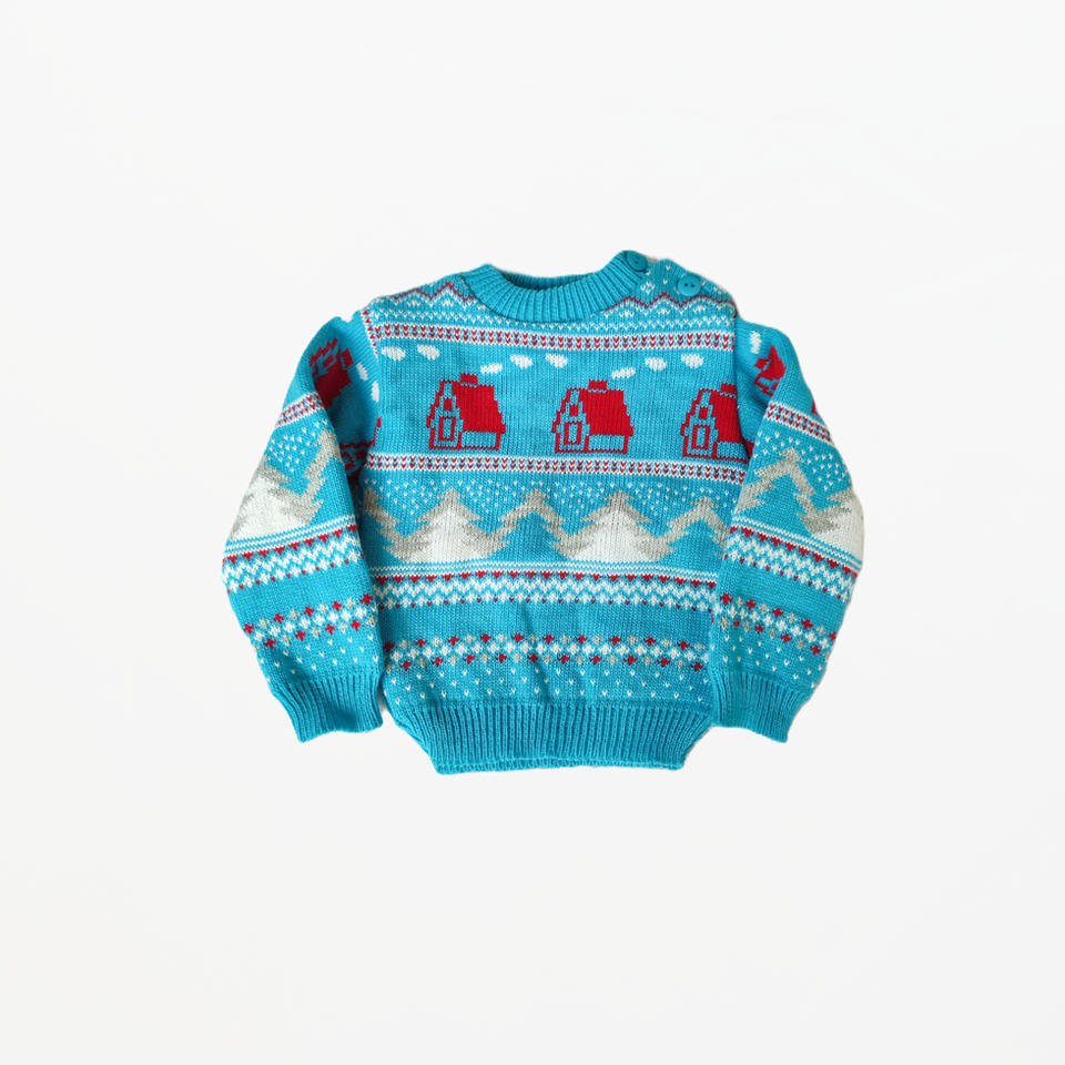 Blue Christmas jumper with red houses and snow covered Christmas tree pattern.
