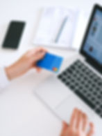 Imagen de unas manos con un computador portátil y una tarjeta de crédito