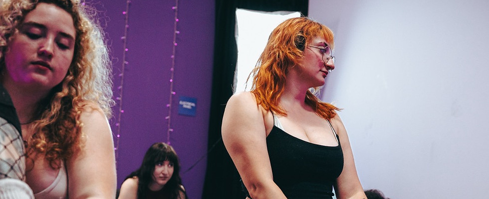 Dancers kneeling on the floor in a class at Xpose Fitness