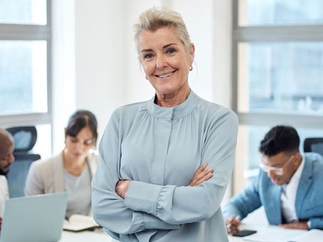 Mature female leader in office with three employees