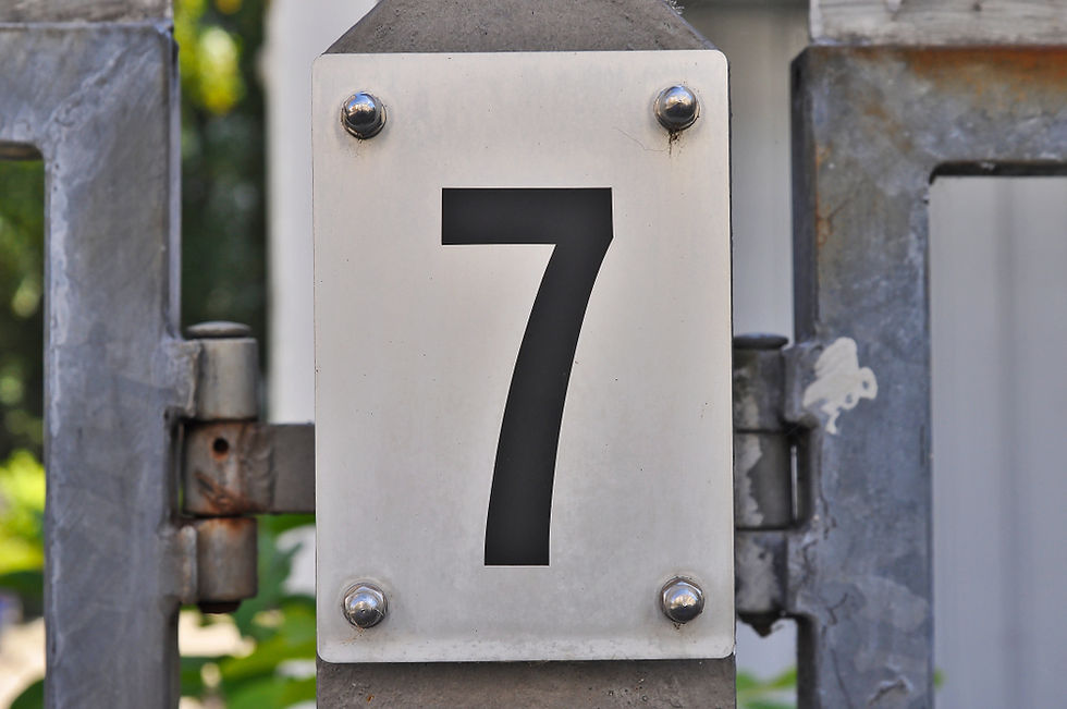 A house number plaque, showing the number seven (7)
