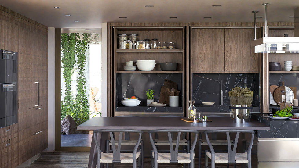Luxury contemporary kitchen featuring custom walnut cabinetry, natural stone countertops, integrated appliances, and a central island within an open-plan residential interior.