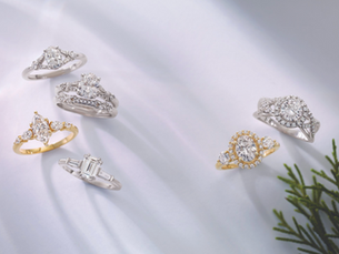 Elegant engagement rings displayed on a plain background, featuring sparkling gemstones and sleek bands.