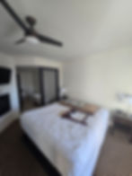 Renovated bedroom with large bed and ceiling fan