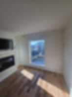 Renovated living room with fireplace, TV, and city view