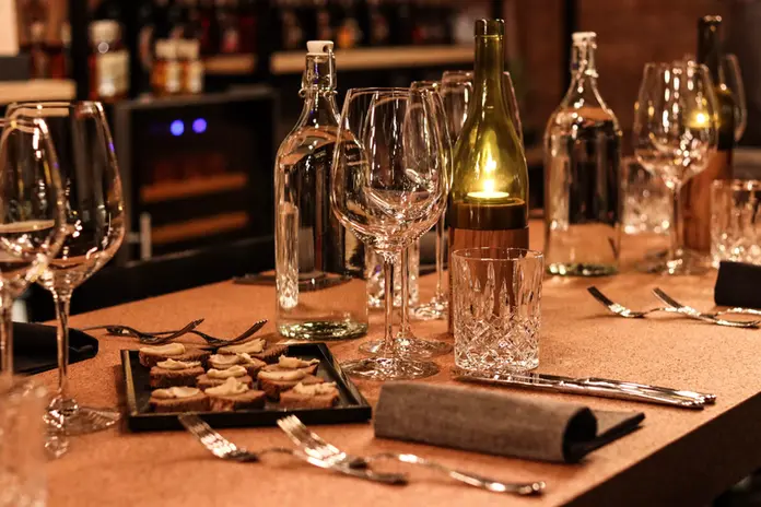 Gedeckter Tisch mit Besteck, Servietten und Weingläsern für eine Degustation in der Weinhandlung Vinothek Hauser in Luzern.