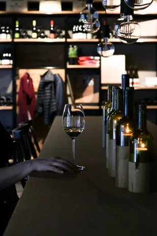 Dame am Tisch in der Vinothek Hauser, einer Weinhandlung in Luzern, am Degustieren.