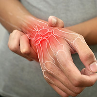 Anonymous person touching his wrist, suferring from arthritis disease, close up against gr