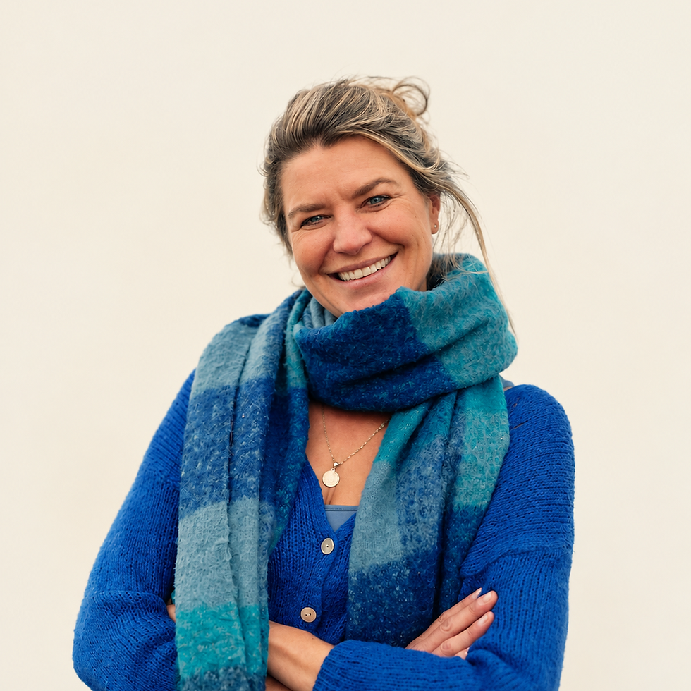 Studio portrait of a smiling woman wearing a cozy blue sweater and a matching patterned scarf. The atmosphere is warm, friendly, and approachable.