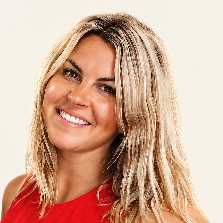 Studio portrait of a blonde woman with a bright smile looking at the camera. The neutral background and soft lighting create a friendly and professional tone.
