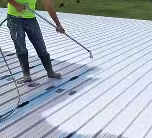 homeguide-contractor-coating-and-sealing-a-metal-roof_jyd7zw.avif