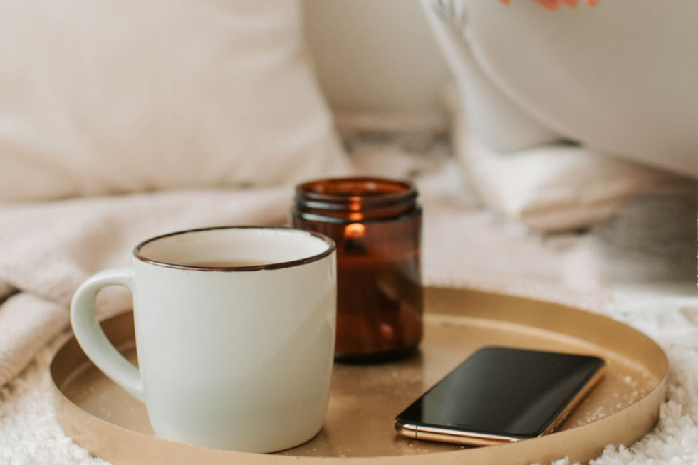 Tasse, bougie et téléphone posés sur un plateau pour une pause bien-être chez soi