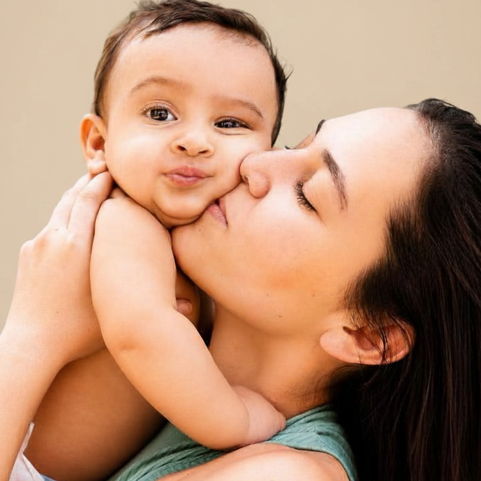 Mère embrassant son bébé dans les bras, fond beige, moment tendre et doux.